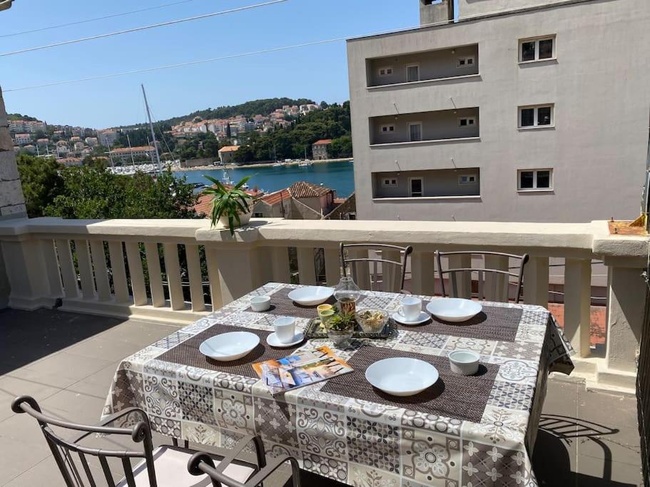 a table on a balcony with a view of the water at Apartment MIAMAR with port sea view in Dubrovnik