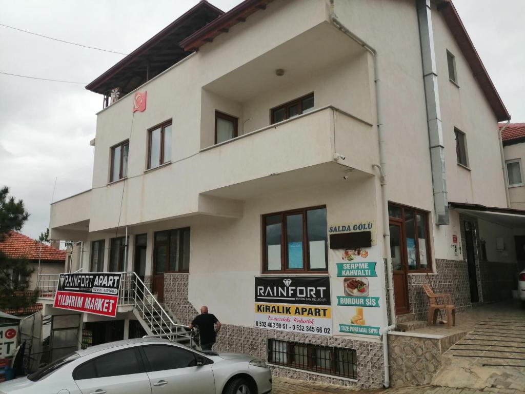 un bâtiment avec une voiture garée devant lui dans l'établissement Salda gölü, à Yeşilova