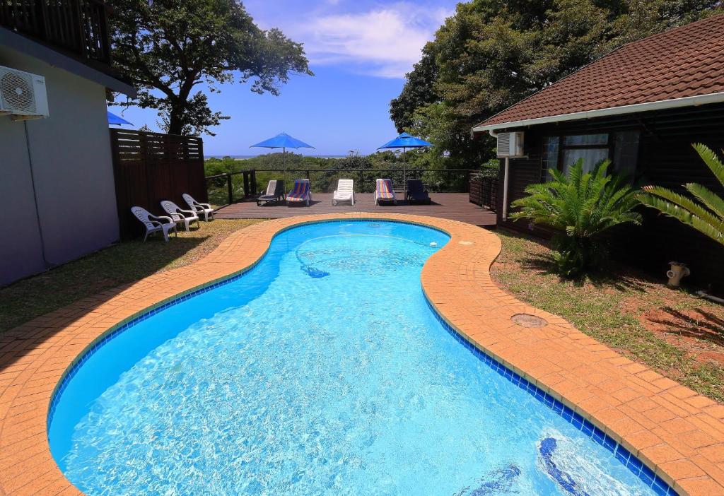 una piscina con un camino de ladrillo a su alrededor en St Lucia Ocean View Lodge, en St Lucia