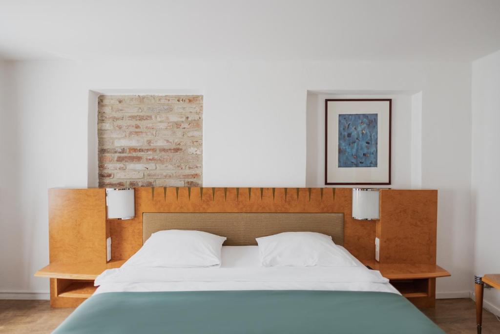 - un lit avec une tête de lit en bois dans une chambre dans l'établissement Hotel Cristallo, à Landshut