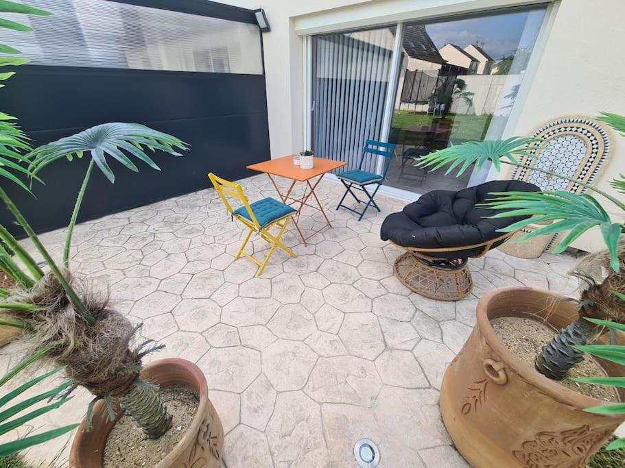 une terrasse avec des plantes en pot, une table et des chaises dans l'établissement Appartement 2 pièces cozy au calme, à Mitry-Mory