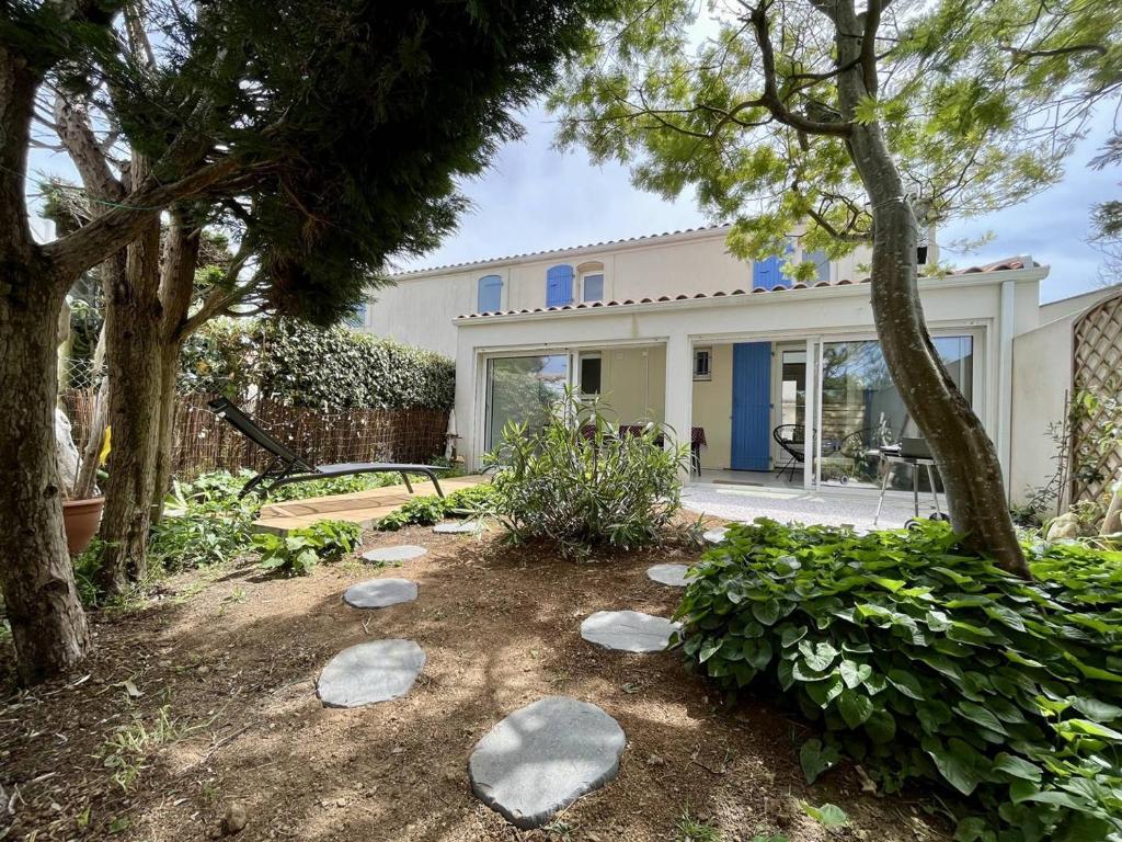 dom z drzewami i kamieniami w ogrodzie w obiekcie Maison rénovée avec mezzanine, jardin, à 750m de la plage de La Rémigeasse, 4 couchages, Wifi inclus - FR-1-246A-217 w mieście Dolus d'Oléron