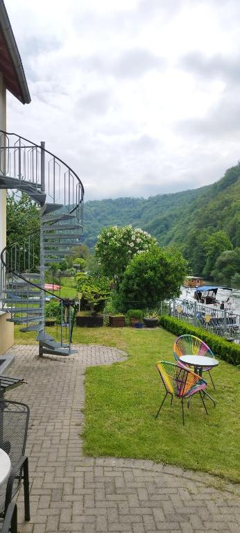 a patio with a table and chairs and a staircase at Lahnzauber Obernhof in Obernhof