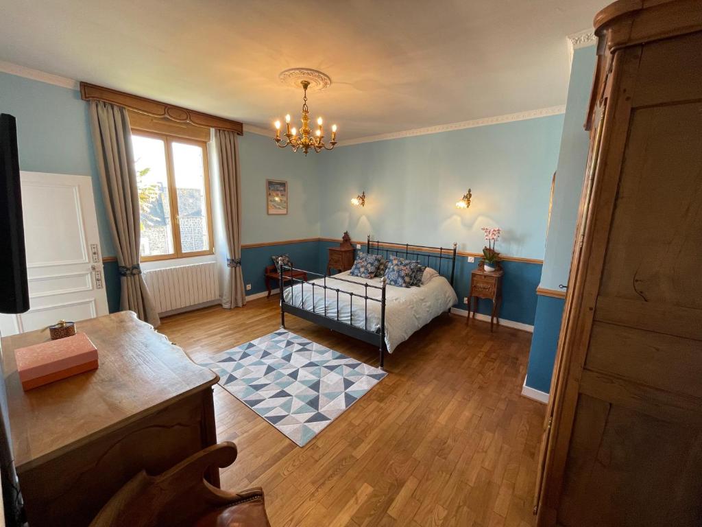 una camera con un letto in una camera blu di La Salmonière a Le Vivier-sur-Mer