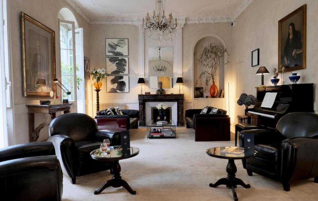 a living room with leather furniture and a fireplace at Hôtel Bristol Pau in Pau