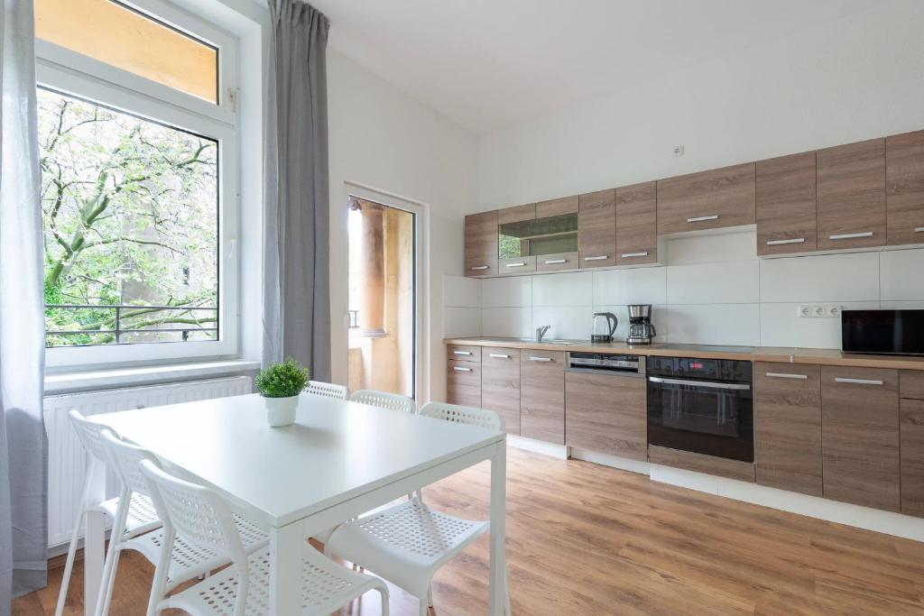 kuchnia z białym stołem i białymi krzesłami w obiekcie T&K Apartments Duisburg 4 Apartments 110qm with balcony w mieście Duisburg