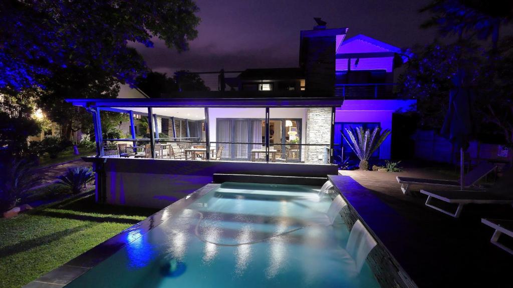 a house with a swimming pool at night at St Lucia Hilltop Guest House in St Lucia