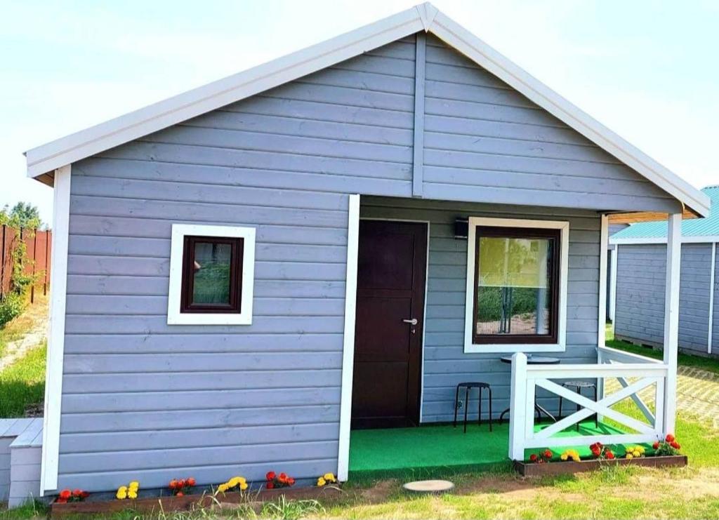 una casa blu con una porta e un portico di u Kapitana a Rowy