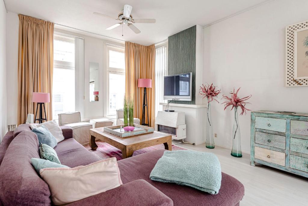een woonkamer met een bank en een tafel bij Zandvoort Zenith - Beautiful Apartment in Zandvoort