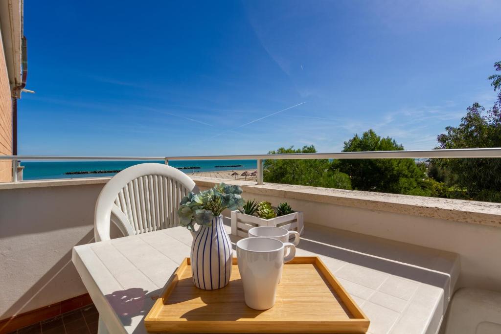 einen Tisch auf einem Balkon mit Meerblick in der Unterkunft Appartamento Bellariva B2 - MyHo Casa in Porto San Giorgio