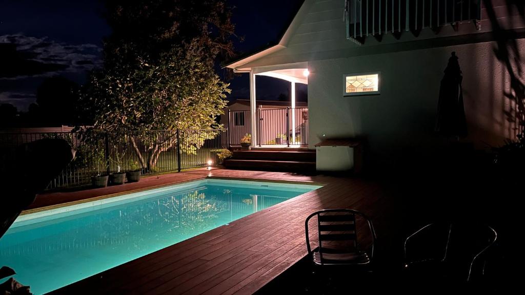 a swimming pool in a yard at night at Live Large in the Village in Havelock North