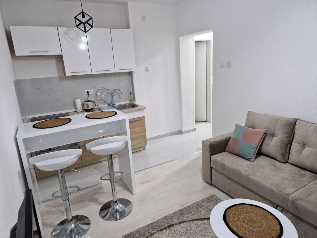 a kitchen and a living room with a couch at Apartman Platan in Trebinje