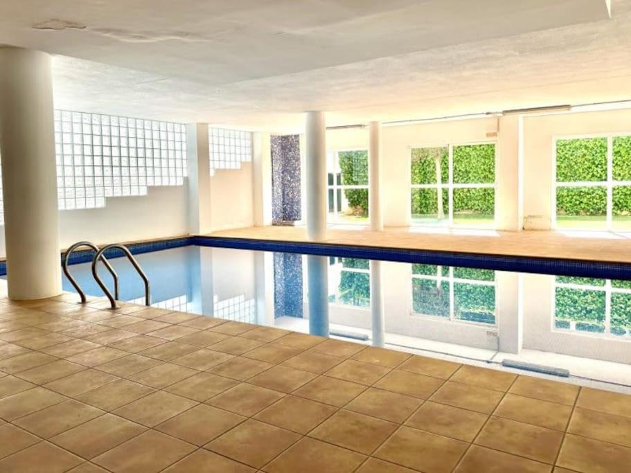 a swimming pool with a chair in a room with windows at Three bedroom apartment, PRIME Javea location in Jávea
