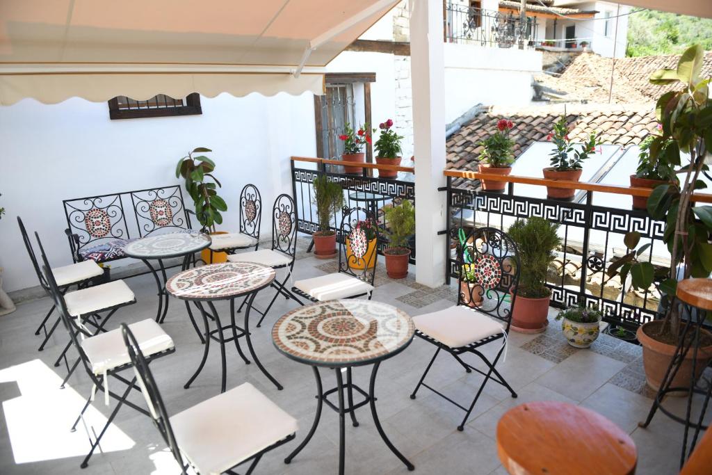 eine Terrasse mit Tischen, Stühlen und Topfpflanzen in der Unterkunft Vila Darla in Berat