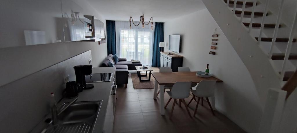 uma cozinha e sala de estar com uma mesa e um sofá em Koje 2 em Graal-Müritz
