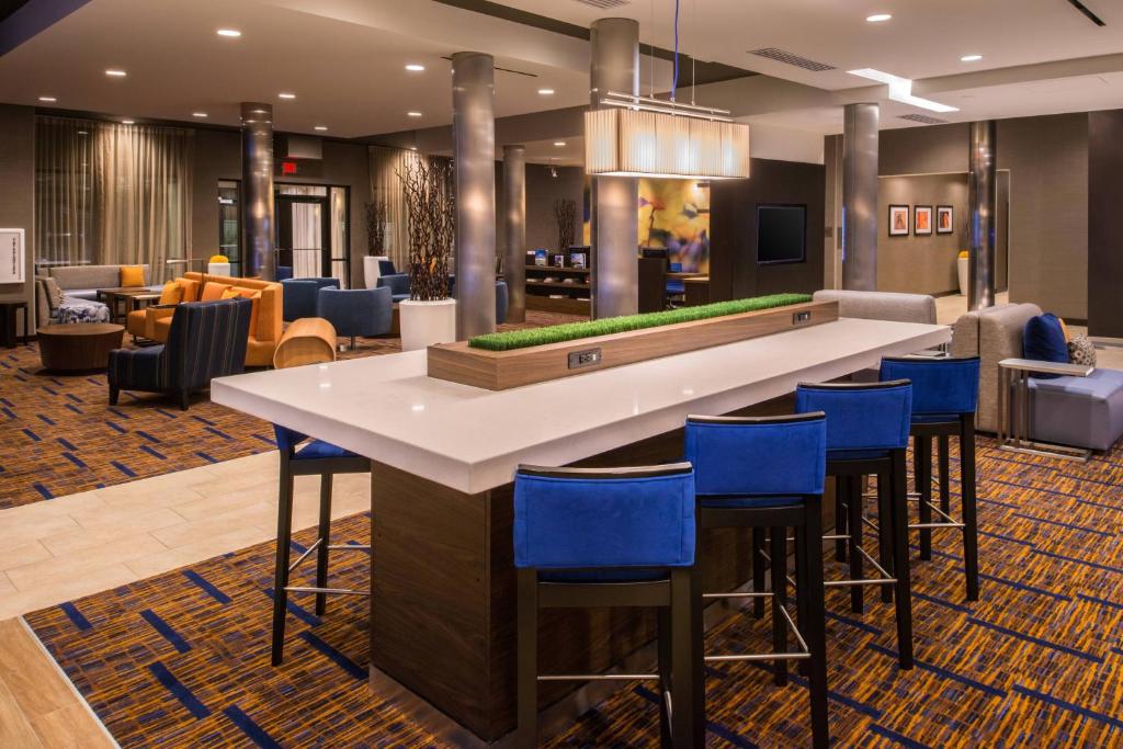 a bar in a hotel lobby with blue stools at Courtyard by Marriott Jacksonville in Jacksonville