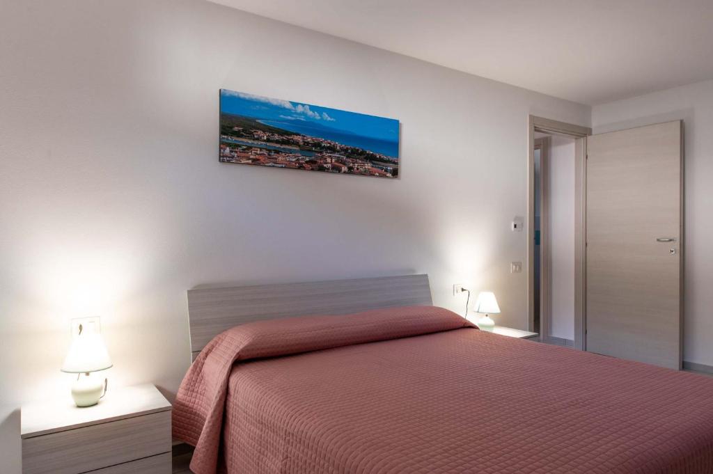 a bedroom with a red bed and two lamps at CAMPI ALTI AL MARE APARTMENTS in Follonica