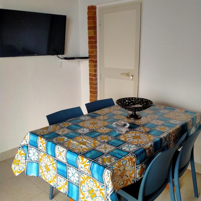 una mesa con sillas y un mantel. en MANSARDA MARE BLUE en Sciacca