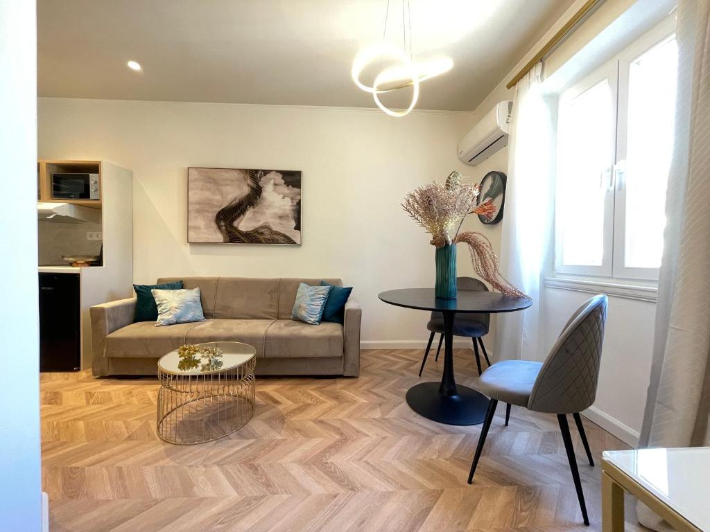 een woonkamer met een bank en een tafel bij Piazza San Rocco Apartments in Corfu-stad