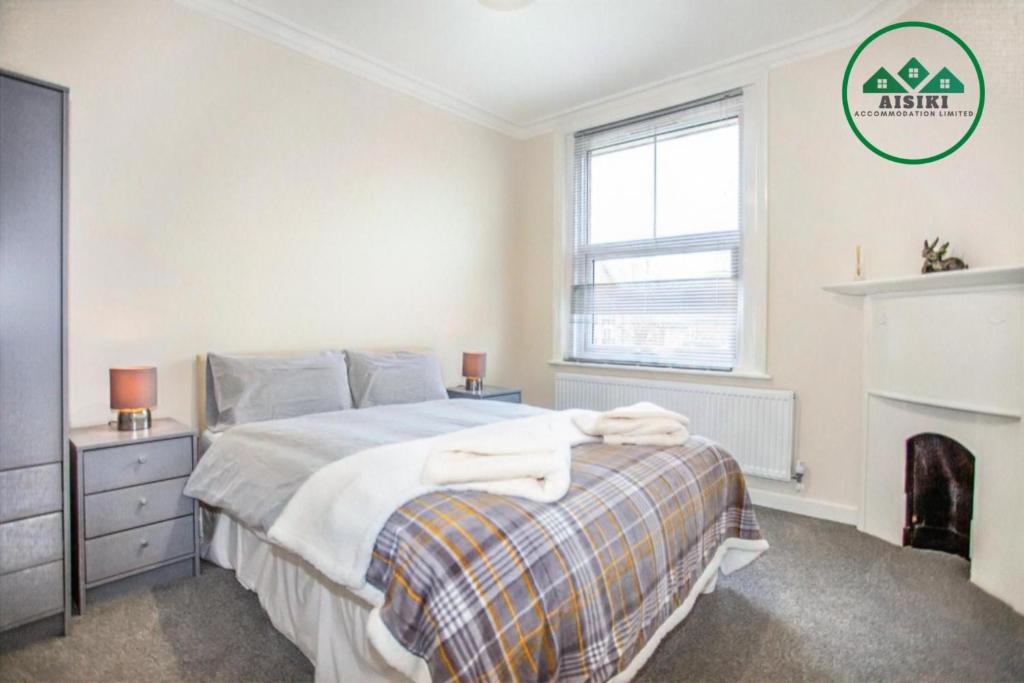 1 dormitorio con 1 cama y chimenea en FW Haute Apartments at Harwoods Road, Multiple 2 Bedroom Pet Friendly Flats, King or Twin or Double beds with FREE WIFI and FREE PARKING, en Watford