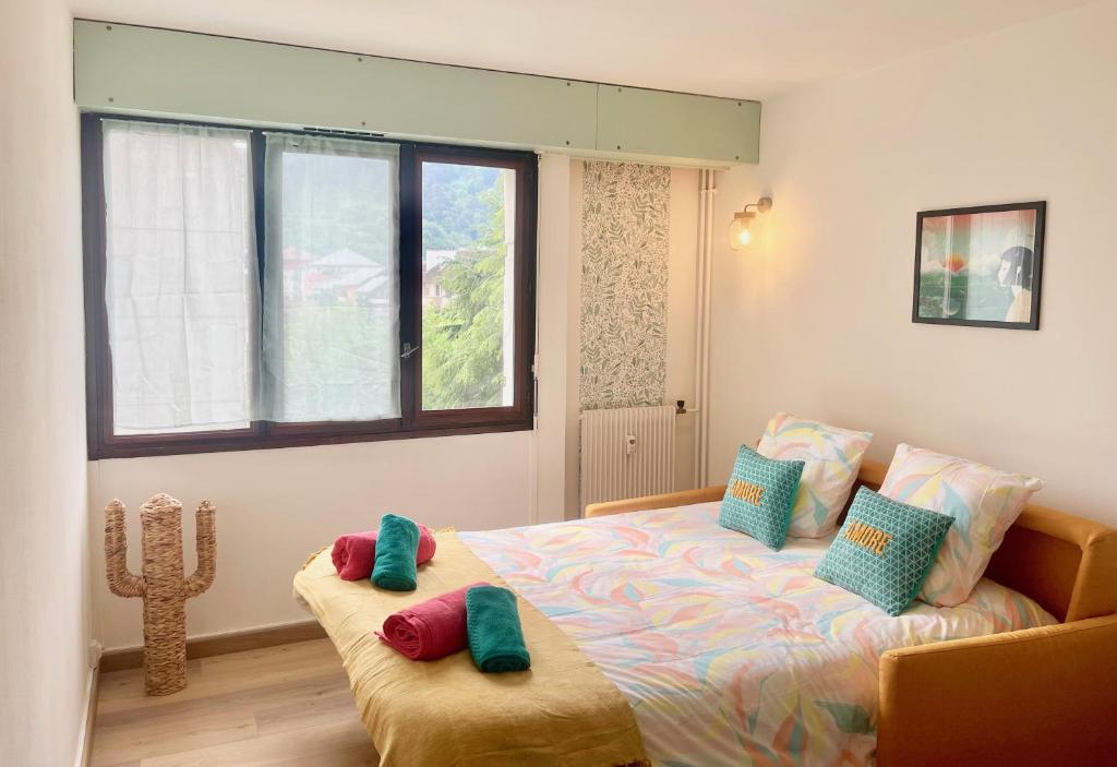 une chambre avec un lit avec des oreillers et une fenêtre dans l'établissement Joli studio proche vieille ville + parking, à Annecy