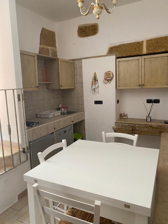 eine Küche mit einem weißen Tisch und Stühlen in der Unterkunft CASA VACANZE DANTE in Mesagne