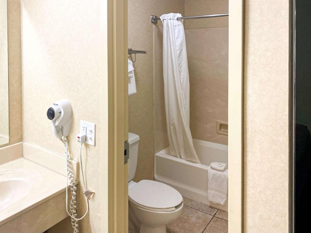 a bathroom with a toilet and a sink and a shower at The Boardwalk Inn in Branson
