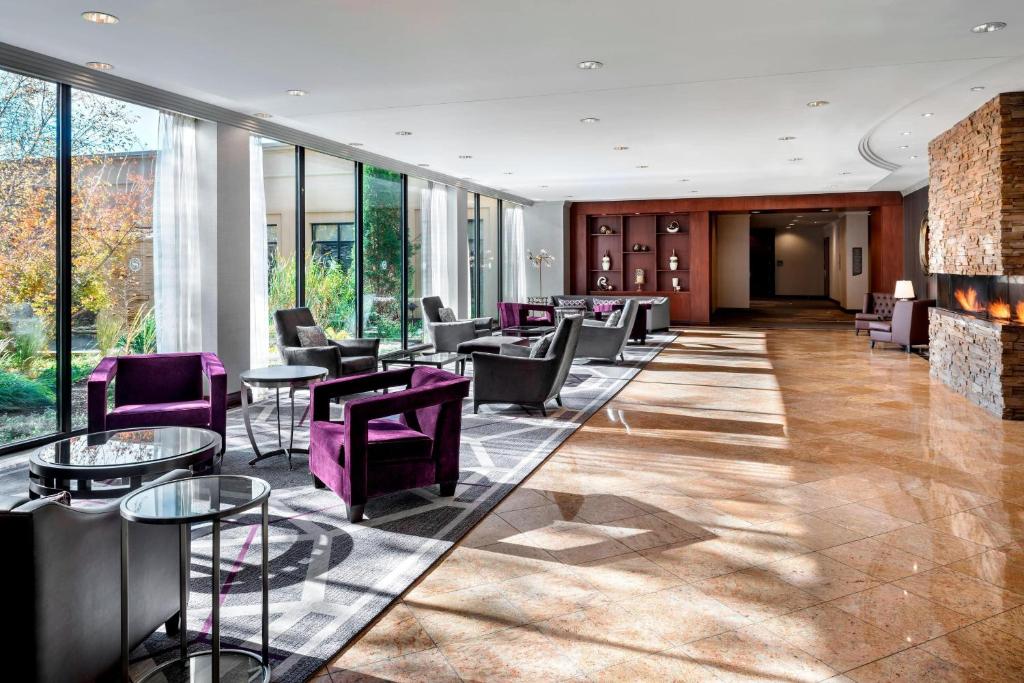 un vestíbulo con sillas y mesas de color púrpura y ventanas en Sheraton Toronto Airport Hotel & Conference Centre, en Toronto