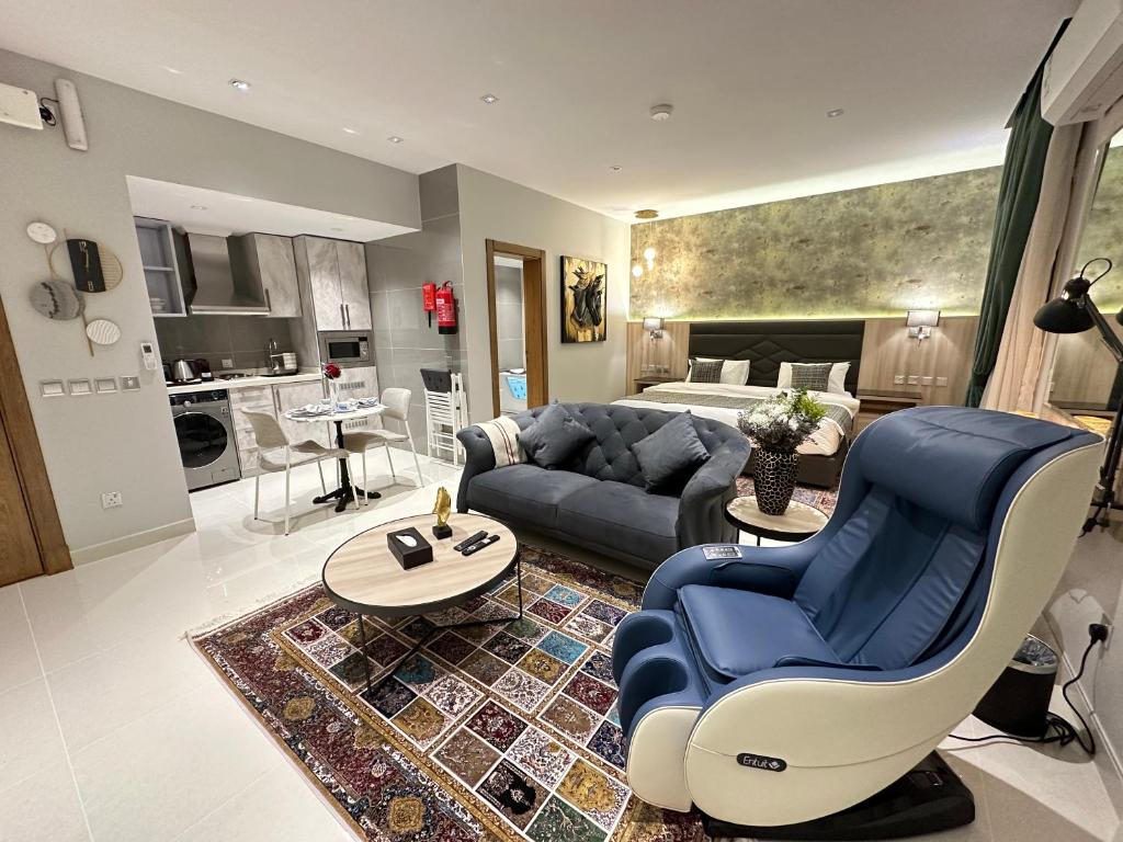 ein Wohnzimmer mit einem blauen Sofa und einem Wohnzimmer in der Unterkunft Jeddah Luxury stay for Self Check-In Apartment in Dschidda
