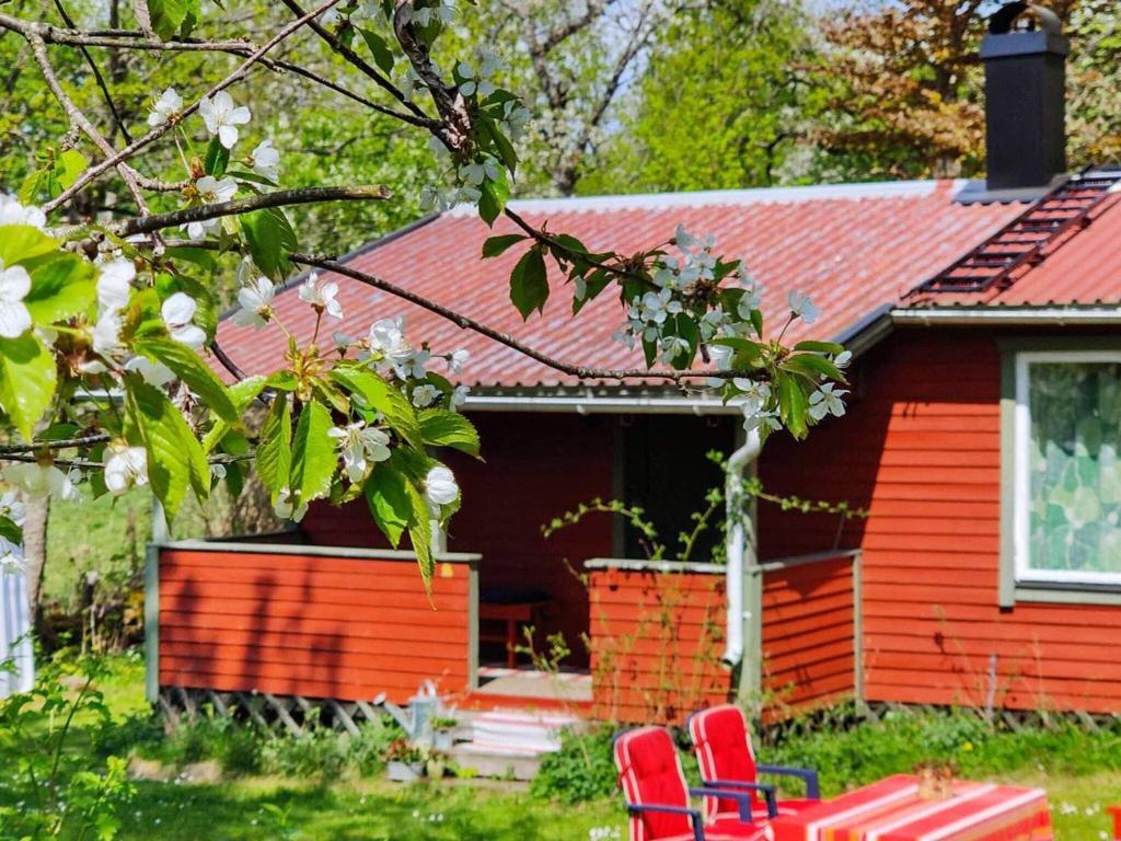 a red house with two red chairs in front of it at Holiday home AXVALL in Axvall