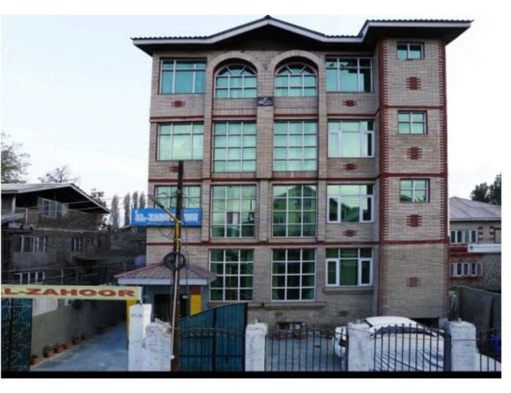 a tall brick building with a sign in front of it at Hotel Al-Zahoor In, Srinagar in Srinagar