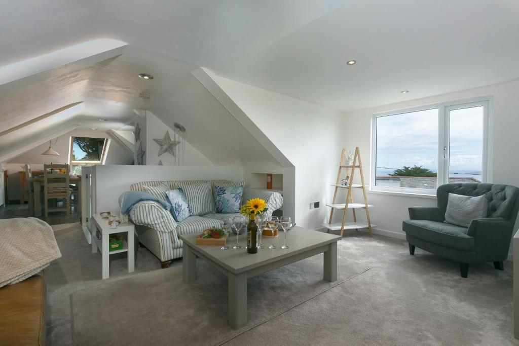 een woonkamer met een bank en een tafel bij Willows in St Ives