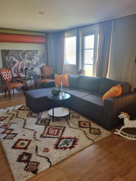 dala källebacka في Stenstorp: غرفة معيشة مع أريكة زرقاء وسجادة
