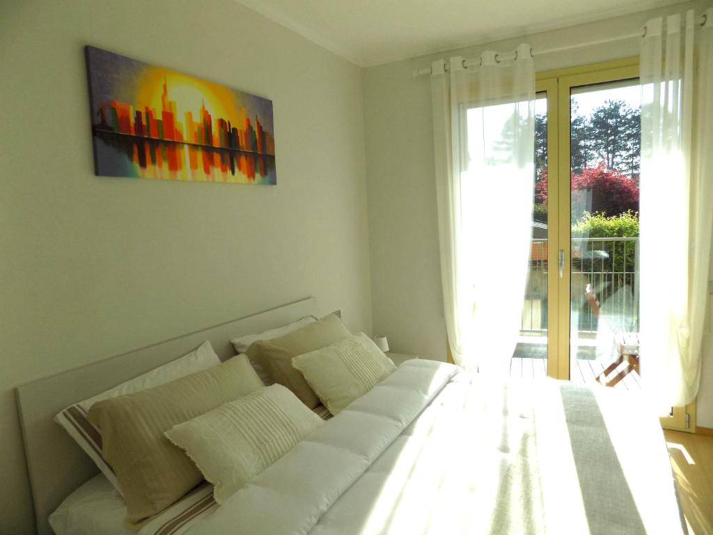 un sofá blanco en una habitación con una pintura en la pared en Lake Como view Apartment en Como