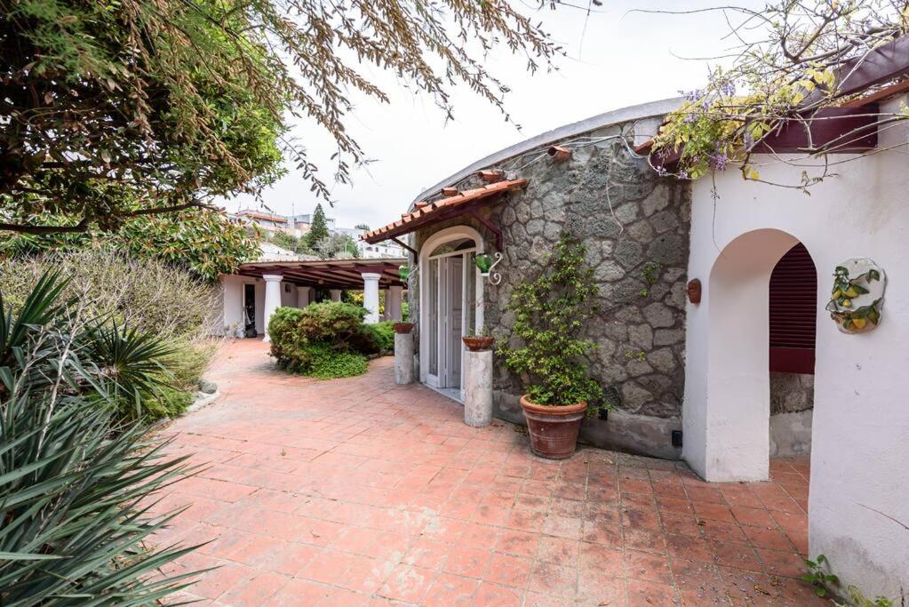 a stone house with a brick walkway next to a building at Villa with private access to the sea in Forio D'Ischia in Ischia