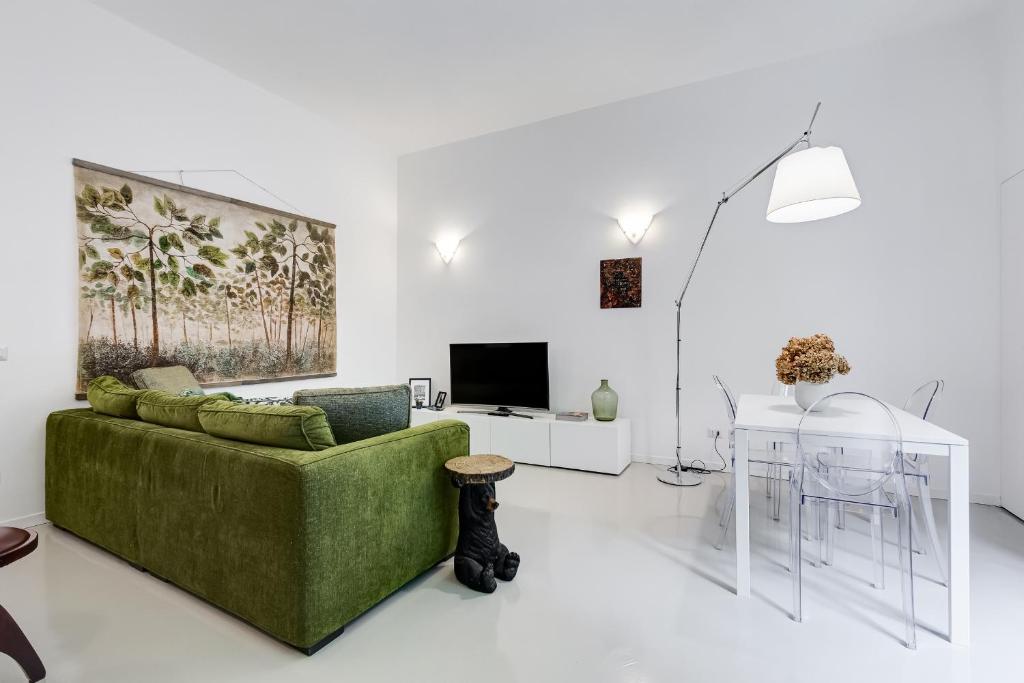 sala de estar con sofá verde y mesa en Colosseo Exclusive House by Premium Suites Collection, en Roma