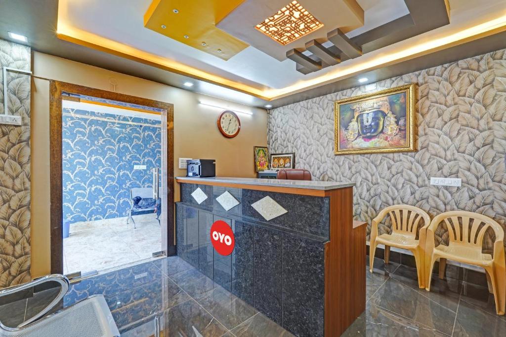 - un bar dans une salle avec un comptoir et des chaises dans l'établissement OYO Flagship Vasudha inn, Hoskote, à Bangalore
