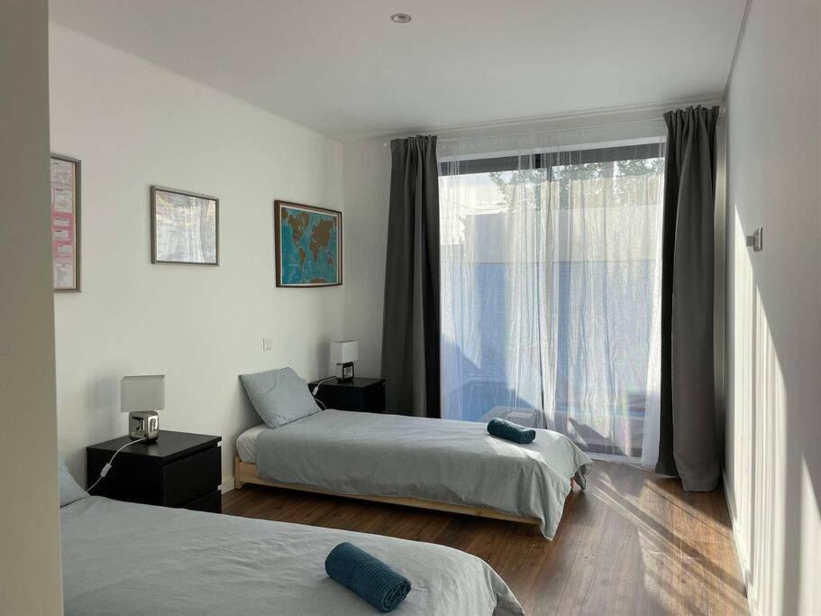 a bedroom with two beds and a large window at The Retreat Fuseta - 3 bed eco villa, own pool in Fuzeta