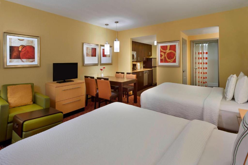 a hotel room with two beds and a dining room at TownePlace Suites by Marriott Thunder Bay in Thunder Bay
