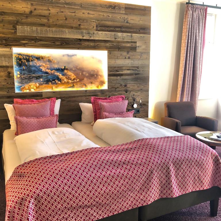 ein Schlafzimmer mit 2 Betten und einem Wandgemälde in der Unterkunft Hotel Nuhnetal in Winterberg