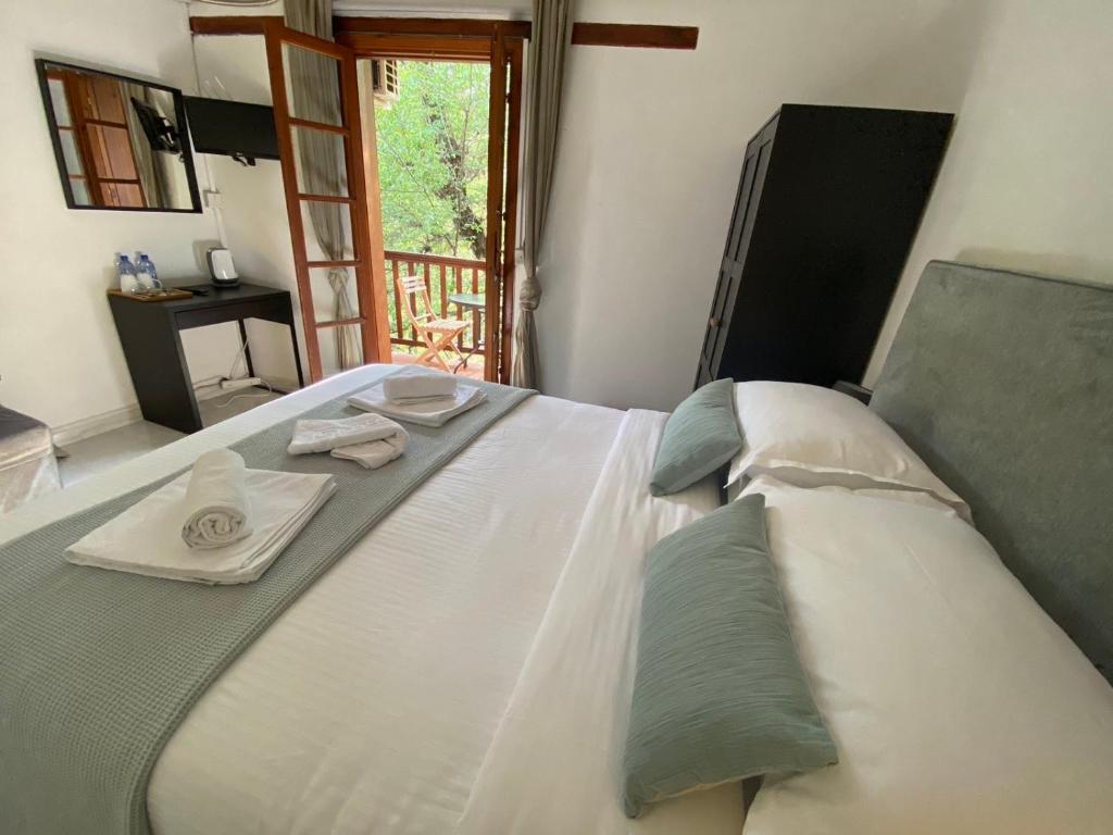 a large white bed with two towels on top of it at GaliniCafe22-suites in Kakopetria