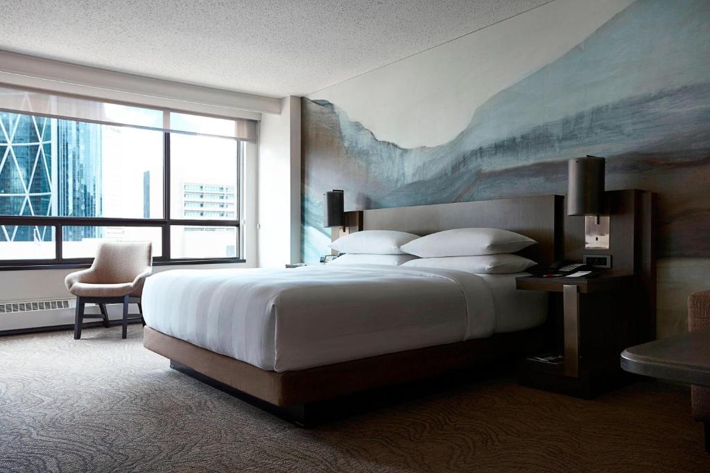 a bedroom with a large bed and a large window at Calgary Marriott Downtown Hotel in Calgary