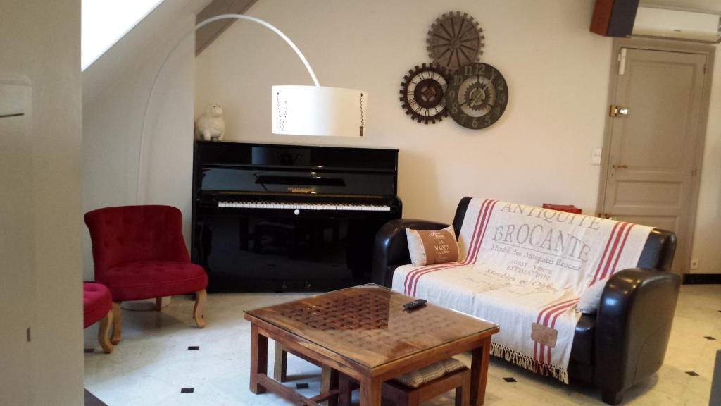 sala de estar con sofá y piano en Appartement De La Vallée, en Saint-Martin-le-Beau