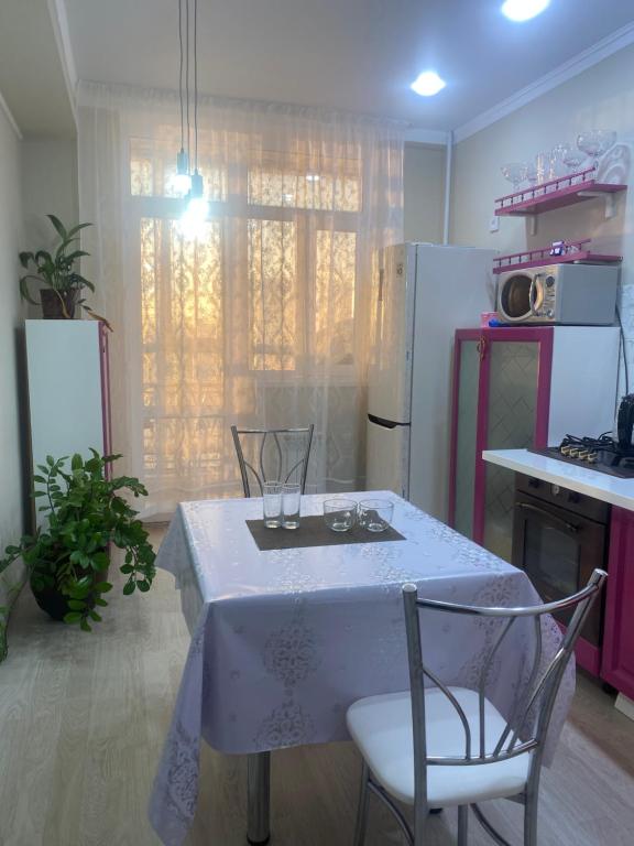 a kitchen with a table with wine glasses on it at Жк Абырой Ризеденс in Atyrau