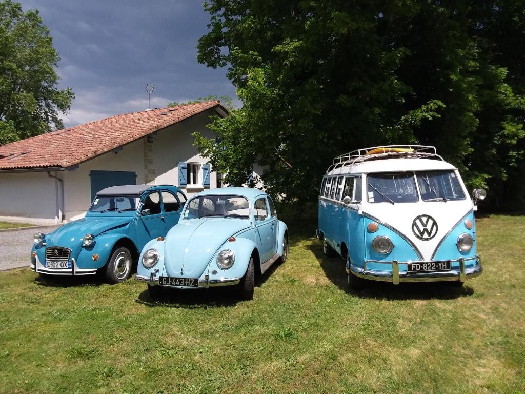 dos coches viejos y un autobús estacionado en el césped en ferme gribeshaoutes, en Préchacq