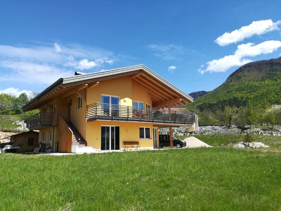 a yellow house with a balcony and a grass field at Il Biancospino Appartamento in Villa 