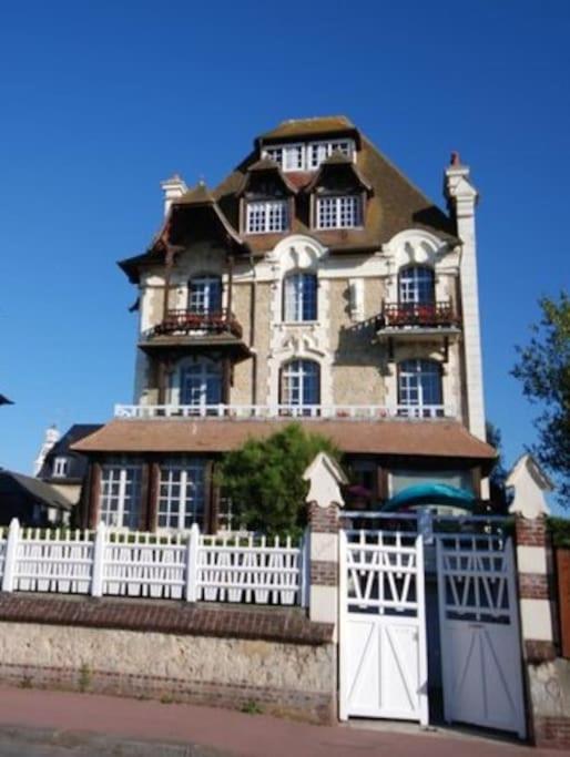 une grande maison avec une clôture blanche et des portes dans l'établissement Les Embruns - Le Balcon - 2eme Etage, à Deauville
