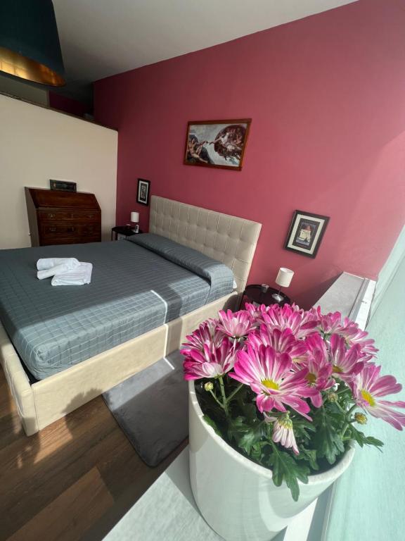 ein Schlafzimmer mit einem Bett und einem Blumentopf in der Unterkunft La torre house in Civitavecchia