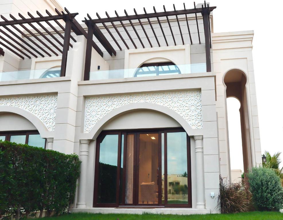 a white house with an archway and windows at Casa Salalah, cozy 2-storey townhouse in Hawana Salalah with free Wi-Fi in Salalah