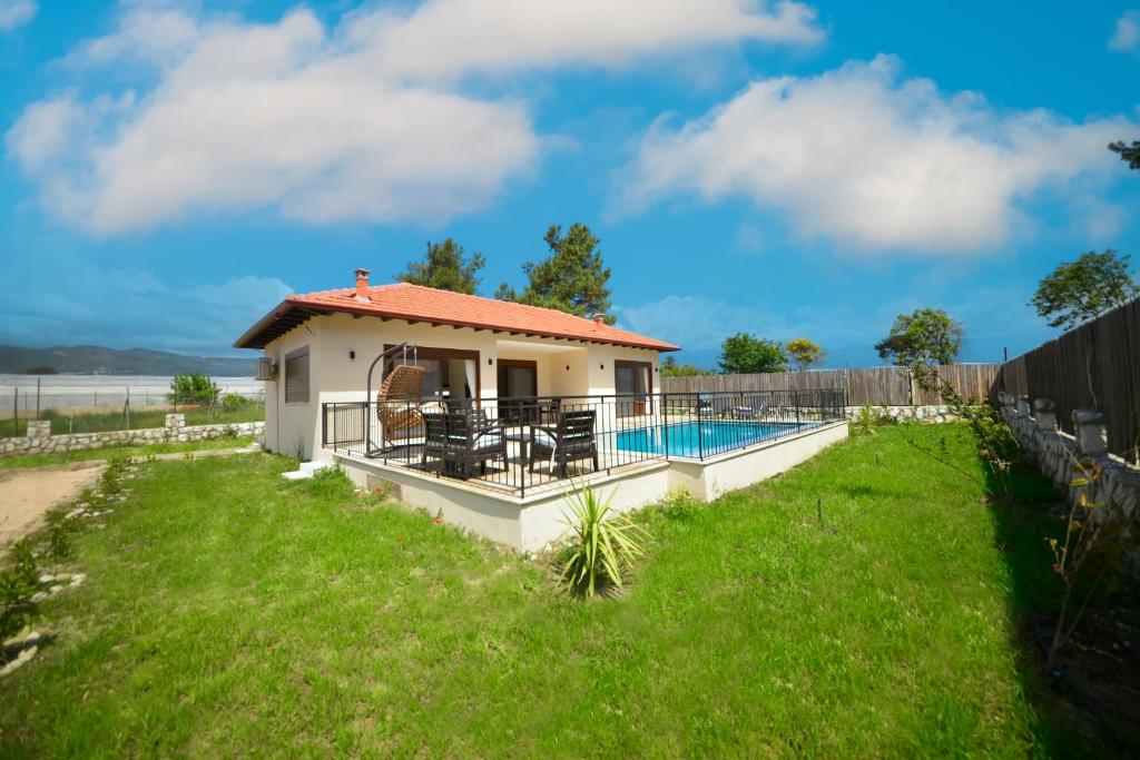 a house with a swimming pool and a fence at Kas Bahce Villalari in Kaş